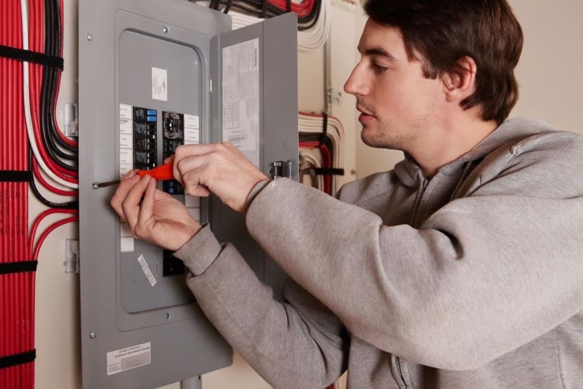 Electrician working on a residential subpanel installation in a detached garage