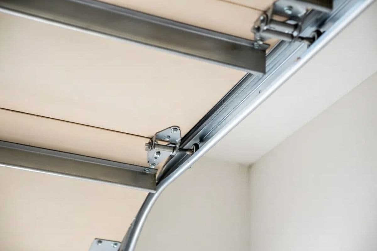 Garage door roller, track, and hinge assembly showing components that cause noise