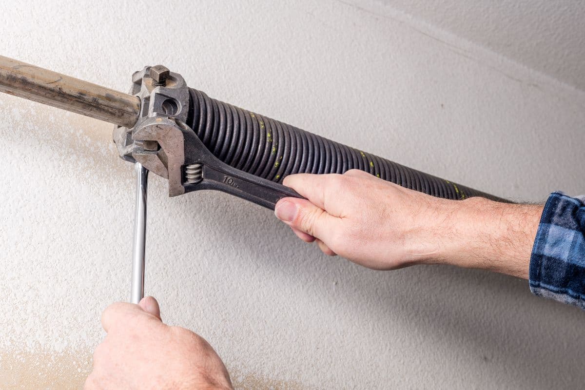 Professional replacing a broken garage door torsion spring